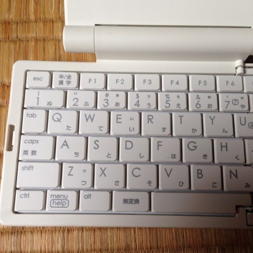 スパークリングシルバー色のポメラ（DM5）のキーボード左半分を正面から撮影した写真。白っぽいキーが整然と並んでいる。各キーは大きさが小さめである。