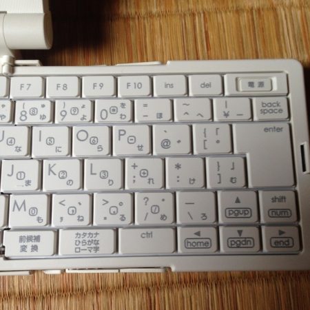 スパークリングシルバー色のポメラ（DM5）のキーボード右半分を正面から撮影した写真。キーボード右上に電源ボタンが見える。