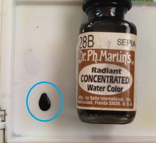 ドクターマーチンカラーインク「28B セピア」の原液を、使い古した白いパレットに置いた写真。原液が濃すぎて、焦茶色のはずの液が、黒いインクにしか見えない。