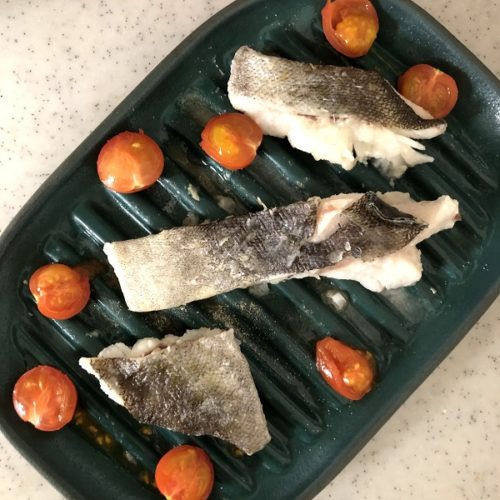 不思議なお皿で鱈とミニトマトを、皿の真上から撮影した写真。