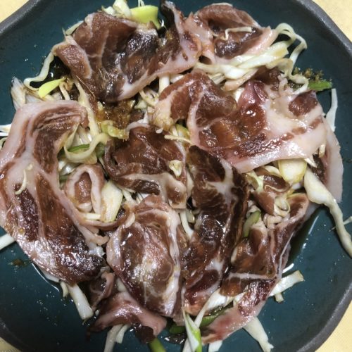 ふしぎなお皿に野菜と豚肉を並べ、焼肉のたれをかけてある写真。青緑色の皿を覆いつくすように、豚肉の薄切りが乗せられている。