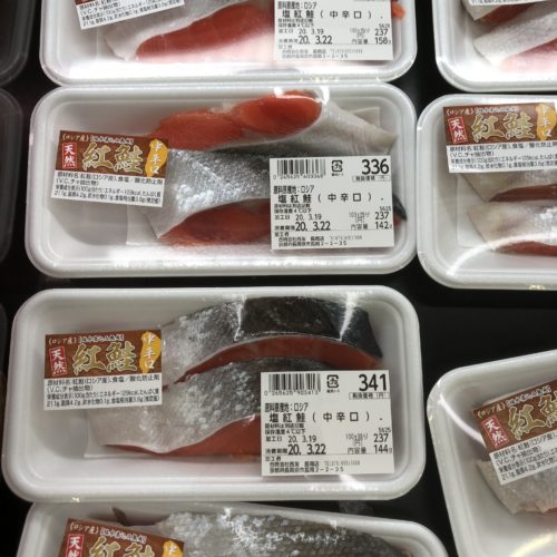 スーパーの鮮魚コーナーに売られている鮭の切り身。パック詰めされており、値札が貼られている。