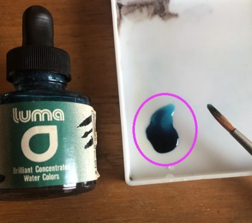 パレットの上で、カラーインク「LUMA」を水で薄め、撮影した写真。透明な青緑色のインク液が写っている。