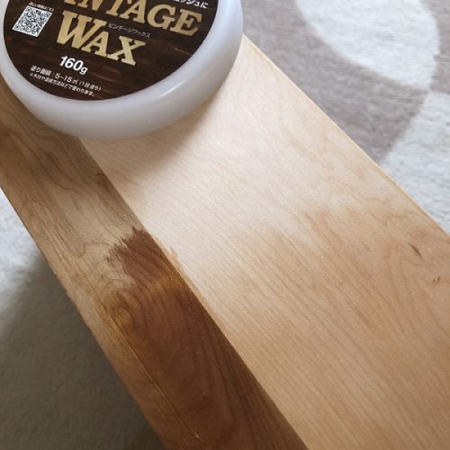 VintageWax(クリアー)を木製家具に塗布している写真。写真手前のワックスを塗布した箇所だけ、木材の色が深くなり、木目がくっきりと目立つようになっている。